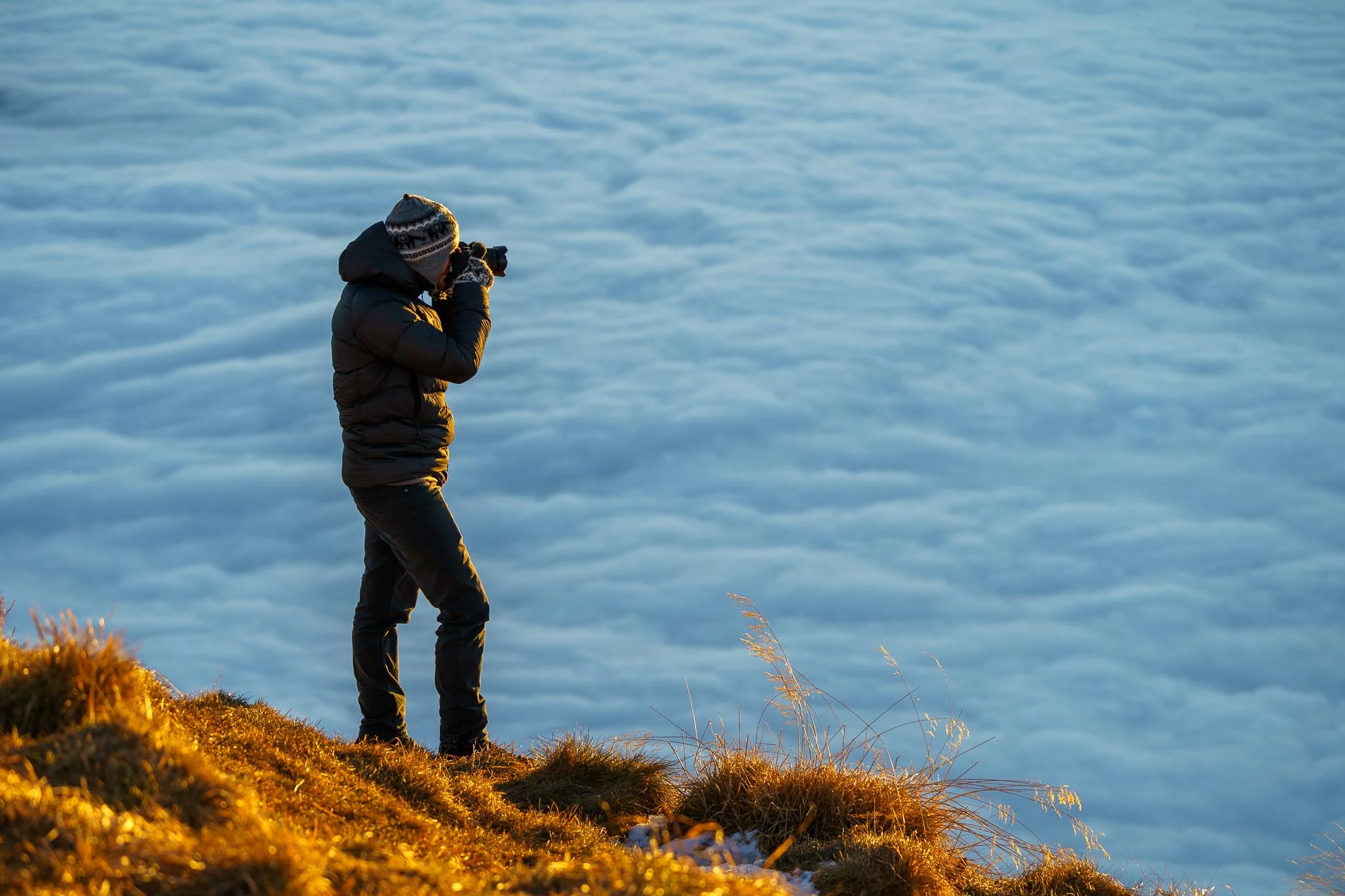 Theo von Büren beim Fotografieren zwischen Wollgras und Berglandschaft